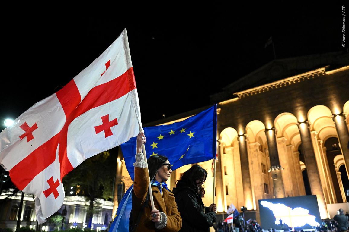 I sostenitori dell'opposizione georgiana sventolano bandiere dell'UE e della Georgia mentre protestano contro i risultati delle elezioni parlamentari di fronte al palazzo del parlamento a Tbilisi, il 4 novembre 2024.